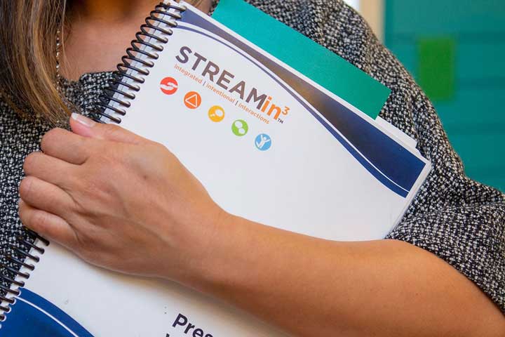 Woman holding curriculum in hand.