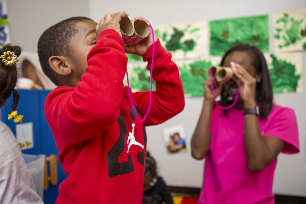 children looking through cardboard binoculars